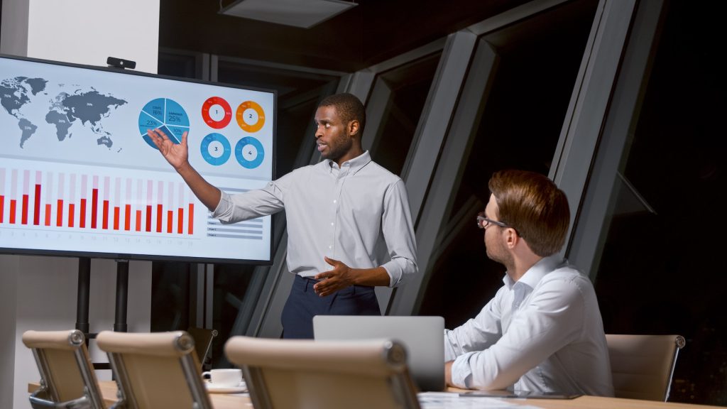 Young analyst telling colleague using tv multimedia